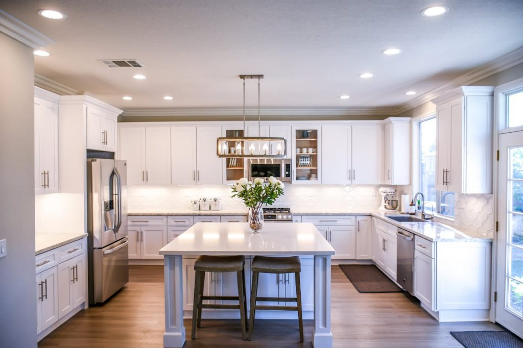 pexels-photo-2724749 Spacious and elegant kitchen featuring white cabinetry, island, and stainless steel appliances.